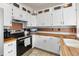 Bright kitchen with white cabinets, butcher block counters, and stainless steel appliances at 113 Rockaway Ave, Castle Rock, CO 80104