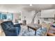 Bright and airy living room featuring wood floors, a large window, and an open layout to kitchen and staircase at 113 Rockaway Ave, Castle Rock, CO 80104