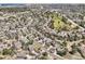 Expansive aerial view of a residential neighborhood with lush greenery, winding streets, and community park at 24487 E Frost Dr, Aurora, CO 80016