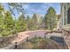 Backyard with stone patio, mature trees, manicured landscaping, and wooden pergola with bench seating at 24487 E Frost Dr, Aurora, CO 80016