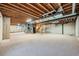 Unfinished basement has exposed beams, a concrete foundation and neutral carpeting throughout the expansive space at 24487 E Frost Dr, Aurora, CO 80016