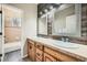 Bathroom with a double vanity, stylish mirrors, and a connecting tiled shower-tub at 24487 E Frost Dr, Aurora, CO 80016