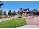 Community clubhouse and event space with covered veranda, stone columns and details, and manicured lawn at 24487 E Frost Dr, Aurora, CO 80016