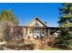 The exterior of the community clubhouse, framed by landscaping and trees has a welcoming entrance and stacked stone facade at 24487 E Frost Dr, Aurora, CO 80016