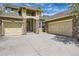 Close up of a lovely home with a three-car garage, stone accents, covered porch, and lush green lawn at 24487 E Frost Dr, Aurora, CO 80016
