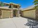 Close-up view of a home's exterior showcasing a three-car garage with stone column accents at 24487 E Frost Dr, Aurora, CO 80016