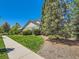 Charming home exterior with lush green lawn, mature trees, and sidewalk access on a sunny day at 24487 E Frost Dr, Aurora, CO 80016