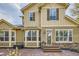 A two-story tan home has brown shutters and trim, stone accents, bay windows and a stone paver patio and entrance at 24487 E Frost Dr, Aurora, CO 80016