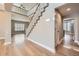 Bright foyer with a staircase, hardwood floors, and an open view to the living room and hallways at 24487 E Frost Dr, Aurora, CO 80016