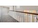 Carpeted hallway with wooden railings offering views of the lower level and natural light at 24487 E Frost Dr, Aurora, CO 80016