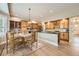 Bright kitchen and dining area with wood cabinets, hardwood floors, granite countertop, and modern appliances at 24487 E Frost Dr, Aurora, CO 80016