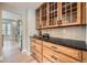 Built-in cabinets with countertop, wine and drinkware display, and stone backsplash at 24487 E Frost Dr, Aurora, CO 80016