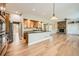 Open-concept kitchen boasts an island, hardwood floors, and flows into a stone fireplace living area at 24487 E Frost Dr, Aurora, CO 80016