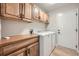 Laundry room features wooden cabinets, countertop, and modern washer and dryer at 24487 E Frost Dr, Aurora, CO 80016