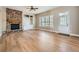 Well-lit living room with hardwood floors, stone fireplace, built-in cabinetry, and large window at 24487 E Frost Dr, Aurora, CO 80016
