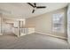 This neutral-toned loft area features plush carpeting, a ceiling fan and large windows with custom wood shutter blinds at 24487 E Frost Dr, Aurora, CO 80016