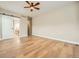 Spacious main bedroom featuring a ceiling fan, hardwood floors, and a sliding barn door at 24487 E Frost Dr, Aurora, CO 80016