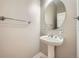 Powder room with pedestal sink, oval mirror, and classic fixtures at 24487 E Frost Dr, Aurora, CO 80016