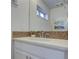 Bathroom featuring mosaic tile backsplash, framed mirror, and a white vanity with chrome fixtures at 5863 N Boston St, Denver, CO 80238