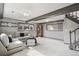 Basement living area featuring modern beams, a stairway, and comfortable seating at 6190 Garrison St, Arvada, CO 80004