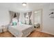 Sunlit bedroom featuring hardwood floors, neutral decor, and a large mirror reflecting the space at 6190 Garrison St, Arvada, CO 80004