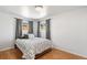 Bedroom with hardwood floors, a queen bed, and two large windows at 6190 Garrison St, Arvada, CO 80004