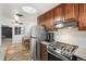 Updated kitchen featuring stainless steel appliances, wood cabinets, granite countertops, and view into the dining room at 6190 Garrison St, Arvada, CO 80004