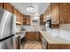 Modern kitchen with stainless steel appliances, granite countertops, and wood cabinets at 6190 Garrison St, Arvada, CO 80004