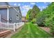 A well-manicured lawn graces the backyard, framed by a charming white picket fence and lush green foliage, enhancing the property's appeal at 8225 W 67Th Pl, Arvada, CO 80004