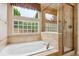 Bright bathroom featuring a tub, shower, and window at 8225 W 67Th Pl, Arvada, CO 80004
