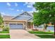 Charming brick home with a well-manicured lawn, a covered porch, and a two-car garage at 8225 W 67Th Pl, Arvada, CO 80004