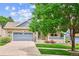 Charming brick home with a well-manicured lawn, a covered porch, and a two-car garage at 8225 W 67Th Pl, Arvada, CO 80004