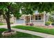 Charming brick home with a well-manicured lawn, a covered porch, and a two-car garage at 8225 W 67Th Pl, Arvada, CO 80004