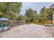The backyard features a large wooden deck and mature trees at 334 Octillo St, Brighton, CO 80601