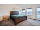 Bedroom featuring a wood bed frame, neutral carpet, modern lighting fixture, and balcony access at 6250 Everett Ct # F, Arvada, CO 80004