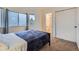 Bedroom featuring neutral carpet, a black bed frame, large windows, and an ensuite bathroom at 6250 Everett Ct # F, Arvada, CO 80004