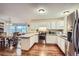 Bright kitchen featuring white cabinets, stainless steel appliances, and an adjacent dining area with a bay window at 6250 Everett Ct # F, Arvada, CO 80004