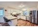 Well-lit kitchen with white cabinetry, stainless steel appliances, and a breakfast bar for casual dining at 6250 Everett Ct # F, Arvada, CO 80004