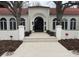 Stunning exterior with an arched doorway, tile roof, and decorative planters leading to the entrance at 4 Cherry Hills Farm Dr, Cherry Hills Village, CO 80113