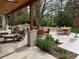 Relaxing patio boasts cozy seating, dining area, outdoor bar, and mature trees for shade at 4 Cherry Hills Farm Dr, Cherry Hills Village, CO 80113
