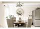 Charming dining area with wood table, fabric chairs, statement mirror, and stainless steel refrigerator at 1365 Columbine St # 204, Denver, CO 80206
