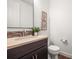 Half bathroom with a dark wood vanity, neutral countertop, and decorated walls at 7875 S Grand Baker St, Aurora, CO 80016