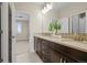 Bathroom featuring double sinks, dark wood cabinetry, tiled floors, and modern lighting at 7875 S Grand Baker St, Aurora, CO 80016