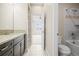 Bathroom featuring shower/tub combo, decorative tile, single sink, and gray wood cabinetry at 7875 S Grand Baker St, Aurora, CO 80016