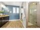 Bright bathroom with blue walls, dual vanity, walk in shower, and tile flooring at 7875 S Grand Baker St, Aurora, CO 80016