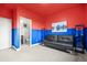Stylish bonus room with red and blue walls, comfortable seating, and modern decor with access to en-suite bathroom at 7875 S Grand Baker St, Aurora, CO 80016