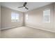 Spacious carpeted bedroom with ceiling fan, and large windows offering natural light at 7875 S Grand Baker St, Aurora, CO 80016