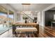 Elegant dining area with a large wooden table, bench seating, and a view of the backyard at 7875 S Grand Baker St, Aurora, CO 80016