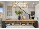 Chic dining space with a rustic wooden table, bench seating, and an elegant chandelier at 7875 S Grand Baker St, Aurora, CO 80016