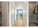 Hallway with wood floors leading to ensuite bathroom and walk-in closet at 7875 S Grand Baker St, Aurora, CO 80016